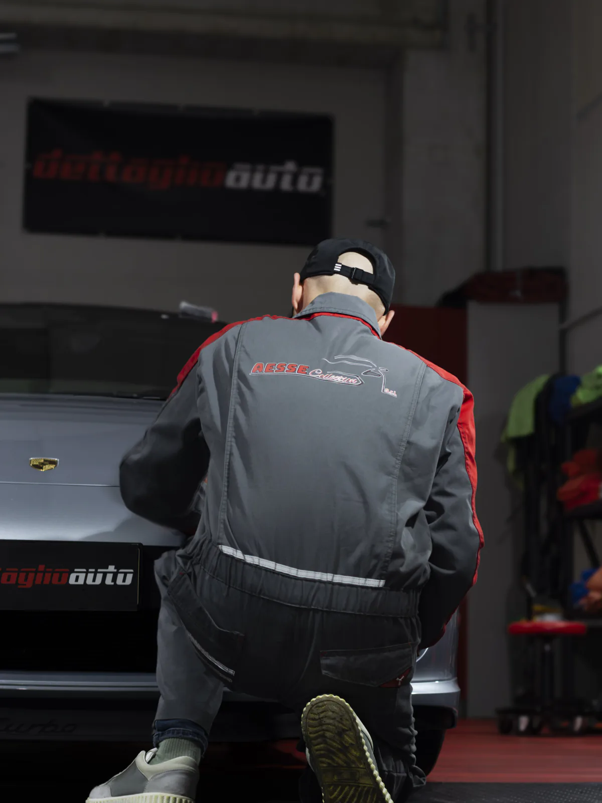 Operatore al lavoro su una Porsche in un centro di car detailing.